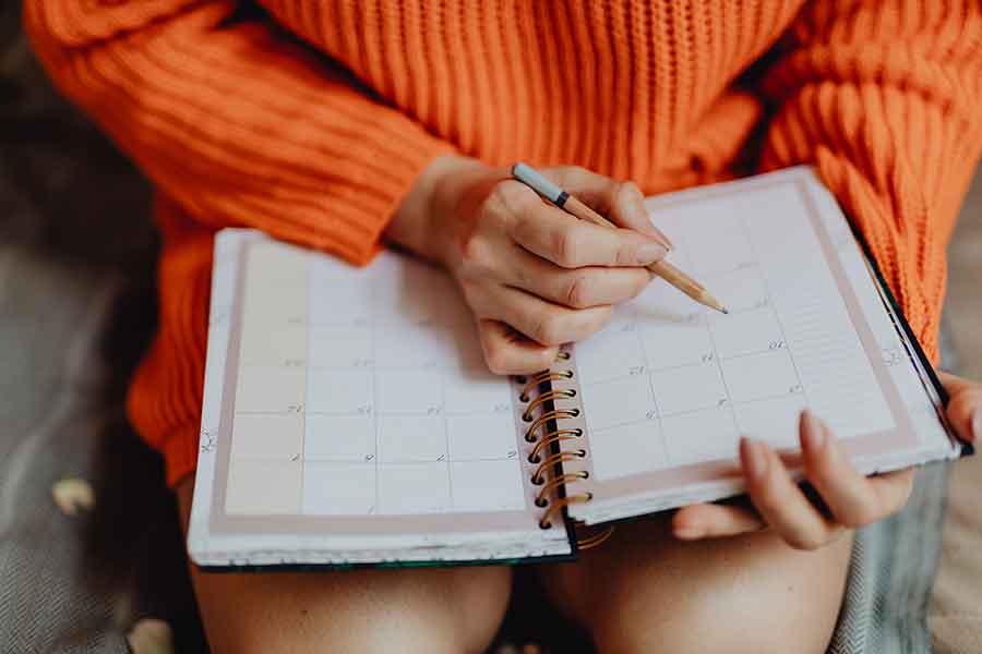 booking policy, girl looking in diary to book an appointment